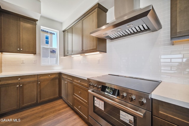 39635 Nicholas Ct, Palmdale, CA 93551 - kitchen featuring wall chimney range hood, stainless steel electric range, backsplash, dark wood finished floors, and light countertops
