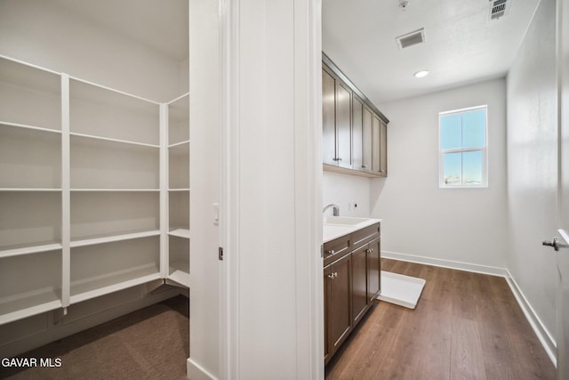 39635 Nicholas Ct, Palmdale, CA 93551 - laundry room with cabinet space, dark wood-style floors, and electric dryer hookup