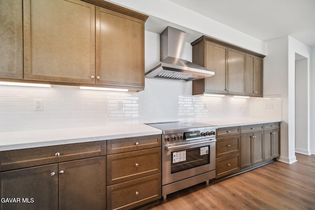 39635 Nicholas Ct, Palmdale, CA 93551 - kitchen with wall chimney range hood, high end range, dark wood-style floors, and backsplash