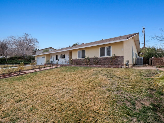 ranch-style home with a garage, cooling unit, and a front yard