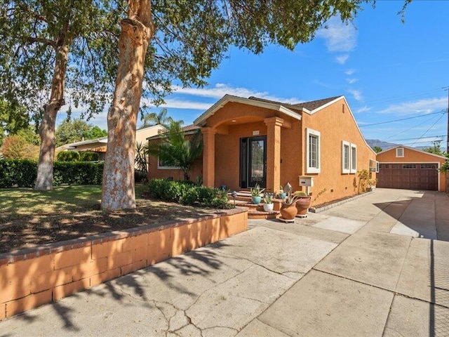 exterior space featuring an outdoor structure and stucco siding