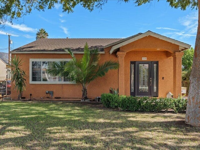 view of front of home with stucco siding and a front yard