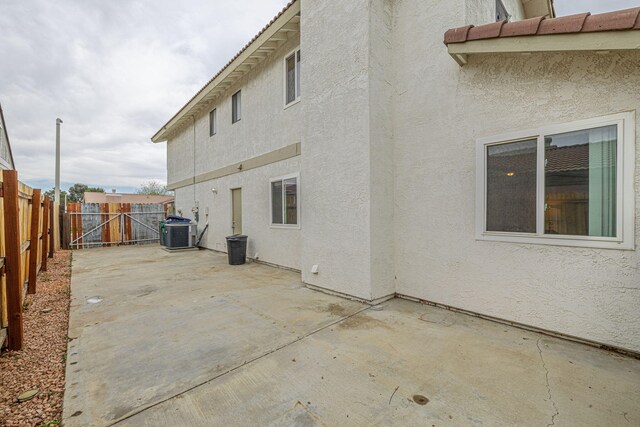 43661 Bravo Ln, Lancaster, CA 93535 - view of side of property with cooling unit, stucco siding, a fenced backyard, and a patio area