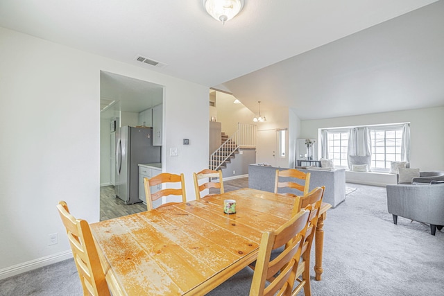 43661 Bravo Ln, Lancaster, CA 93535 - dining room featuring stairway, light colored carpet, baseboards, a chandelier, and vaulted ceiling