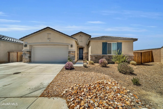 3932 Birchwood Ave, Rosamond, CA 93560 - view of front of home with stone siding, stucco siding, driveway, and a garage