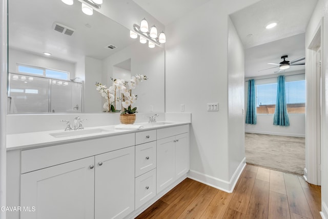 3932 Birchwood Ave, Rosamond, CA 93560 - bathroom with double vanity, wood-type flooring, a ceiling fan, and a shower