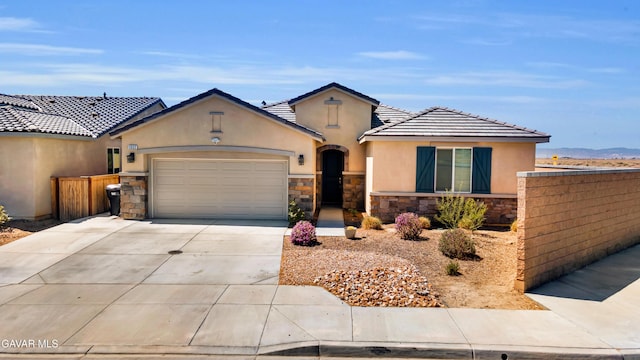3932 Birchwood Ave, Rosamond, CA 93560 - view of front facade featuring stone siding, stucco siding, concrete driveway, a garage, and a tiled roof
