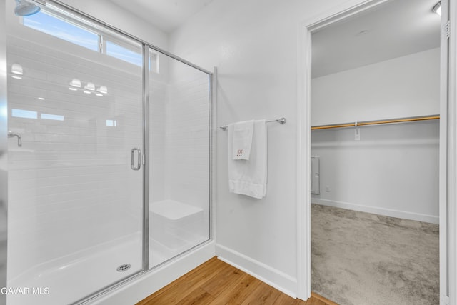 3932 Birchwood Ave, Rosamond, CA 93560 - bathroom featuring a shower stall, a walk in closet, and wood finished floors