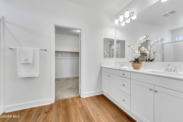 3932 Birchwood Ave, Rosamond, CA 93560 - bathroom with double vanity, wood finished floors, and a walk in closet
