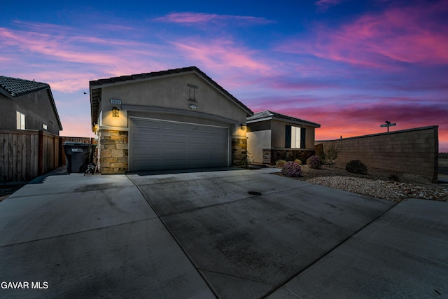 3932 Birchwood Ave, Rosamond, CA 93560 - ranch-style home with stone siding, stucco siding, concrete driveway, and a garage