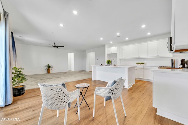 3932 Birchwood Ave, Rosamond, CA 93560 - kitchen with a kitchen island with sink, stainless steel microwave, a ceiling fan, recessed lighting, and white cabinets