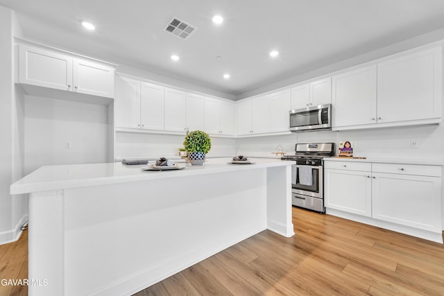 3932 Birchwood Ave, Rosamond, CA 93560 - kitchen with stainless steel appliances, white cabinets, light wood-type flooring, light countertops, and recessed lighting