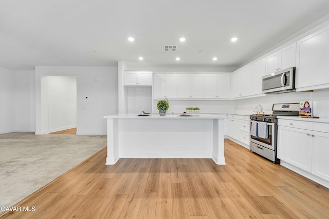 3932 Birchwood Ave, Rosamond, CA 93560 - kitchen with stainless steel appliances, a center island with sink, white cabinetry, and recessed lighting