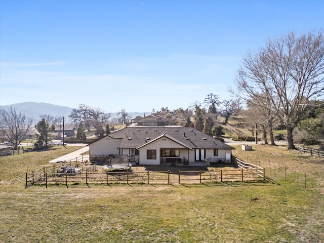 back of house with a lawn, a mountain view, and fence private yard