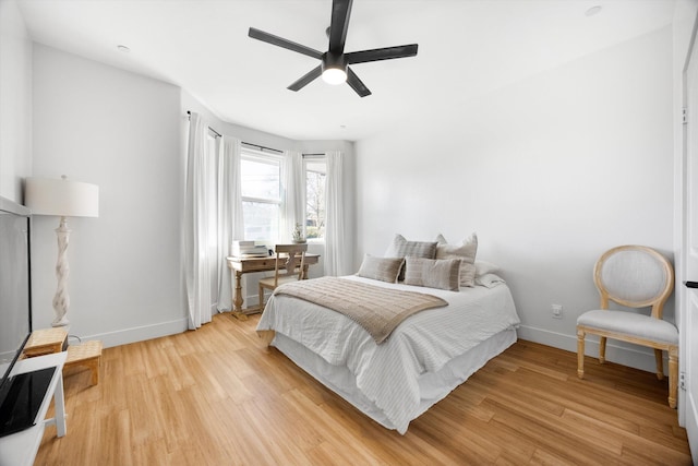 bedroom featuring light wood finished floors, a ceiling fan, and baseboards