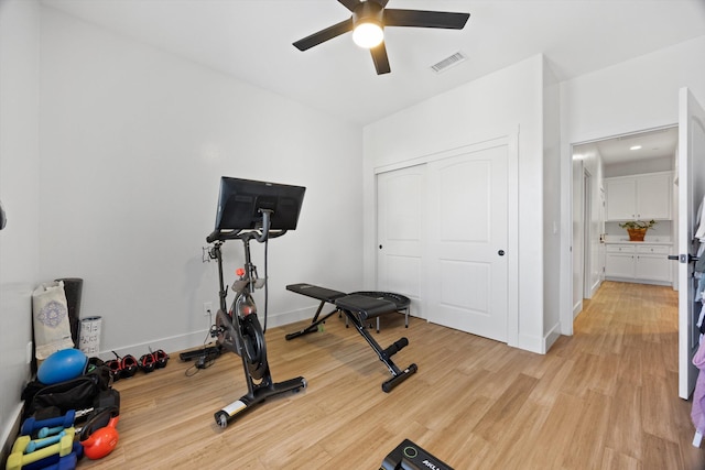 workout room featuring visible vents, light wood-style flooring, baseboards, and ceiling fan