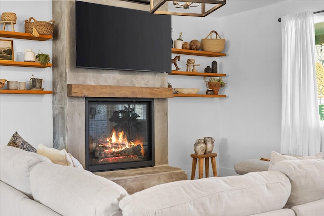 living area featuring a glass covered fireplace