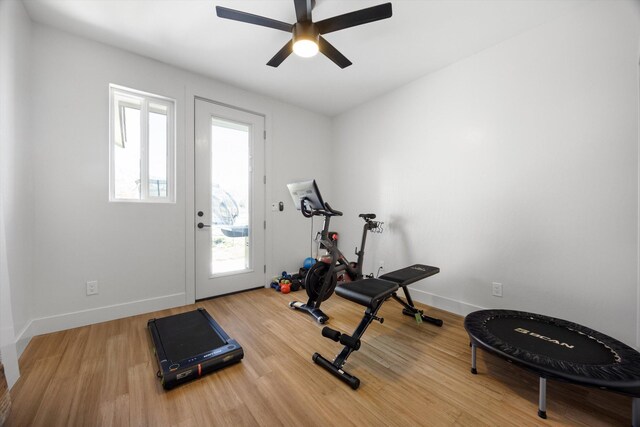 workout room featuring ceiling fan, baseboards, and wood finished floors