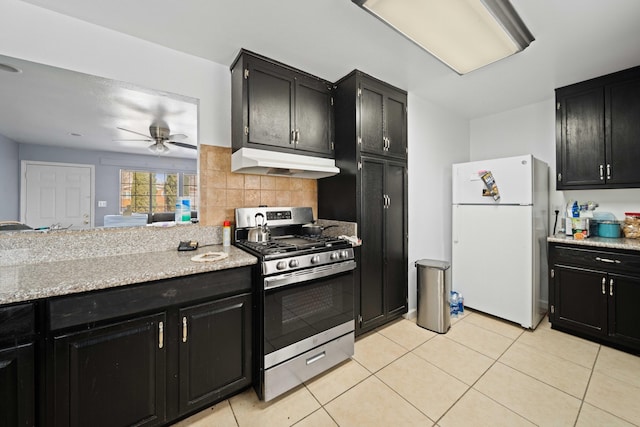 15872 Rexroth St, Mojave, CA 93501 - kitchen with freestanding refrigerator, stainless steel gas range oven, under cabinet range hood, and dark cabinets