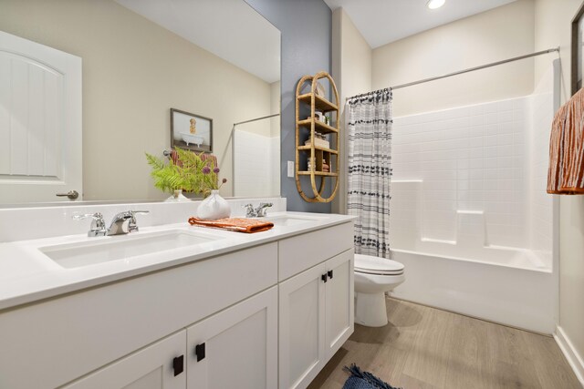 bathroom with a sink, toilet, shower / bathtub combination with curtain, and wood finished floors