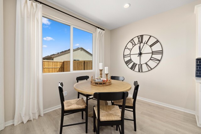 dining room featuring light wood-style flooring, baseboards, and recessed lighting