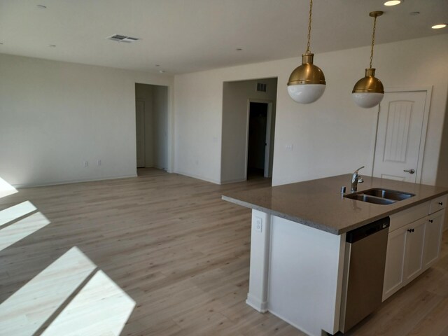 kitchen with a sink, open floor plan, visible vents, dishwasher, and light wood-style floors