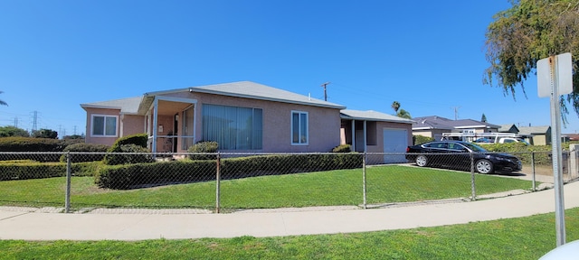 view of front of house featuring a front lawn, fence private yard, stucco siding, a garage, and driveway