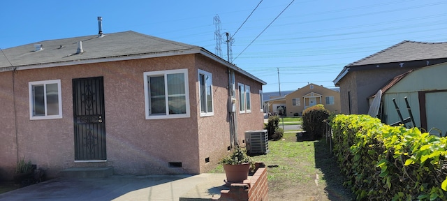 view of property exterior featuring crawl space, central AC unit, and stucco siding