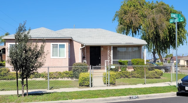 bungalow with a gate, a fenced front yard, and stucco siding