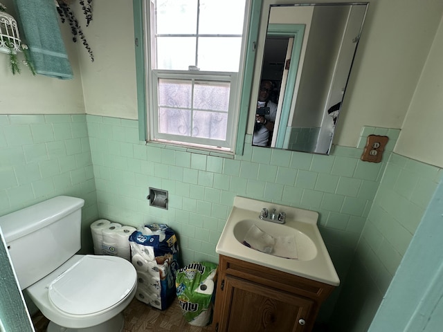 bathroom with vanity, tile walls, and toilet