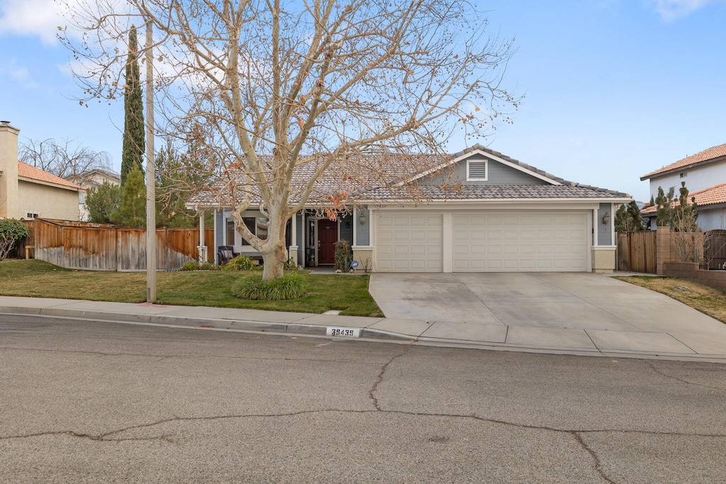 single story home featuring a garage and a front lawn