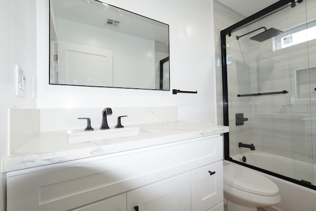 full bathroom with vanity, enclosed tub / shower combo, and toilet