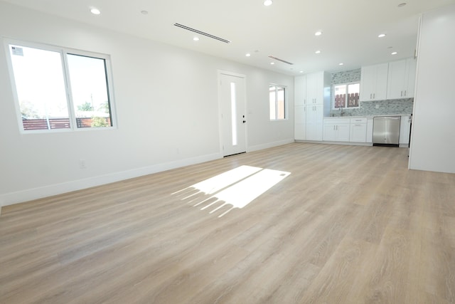 unfurnished living room featuring sink and light wood-type flooring