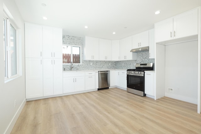 kitchen featuring tasteful backsplash, sink, stainless steel appliances, and white cabinets