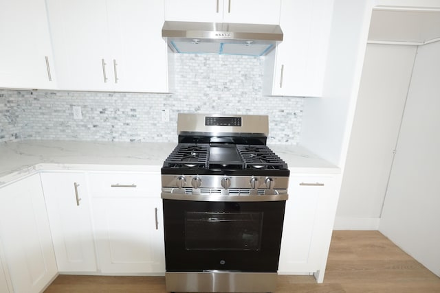 kitchen with white cabinetry, light stone countertops, range hood, and gas stove