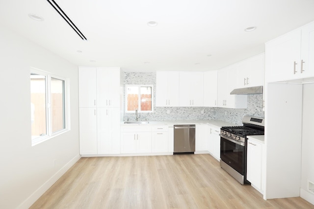 kitchen featuring appliances with stainless steel finishes, sink, decorative backsplash, and white cabinets