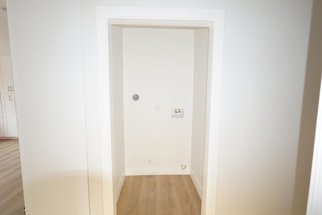 clothes washing area with light hardwood / wood-style floors