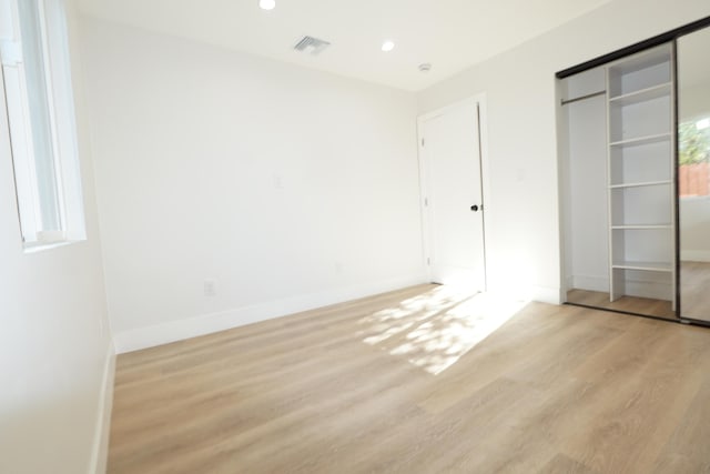 unfurnished bedroom featuring a closet and light hardwood / wood-style flooring