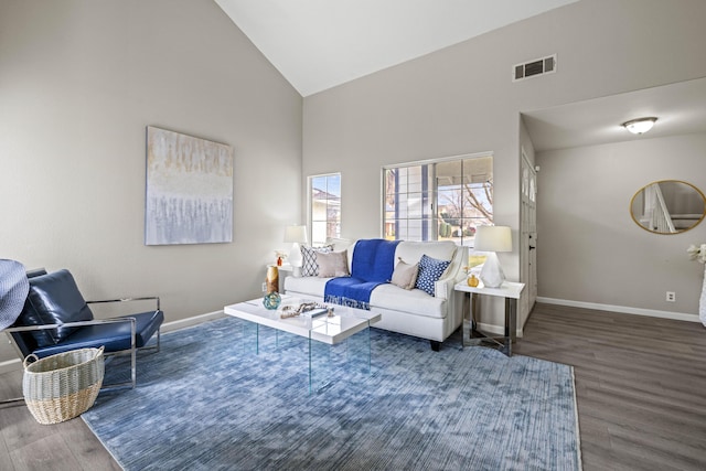 living room with dark wood-type flooring and high vaulted ceiling