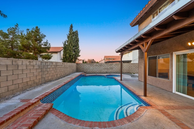 pool at dusk featuring a patio area