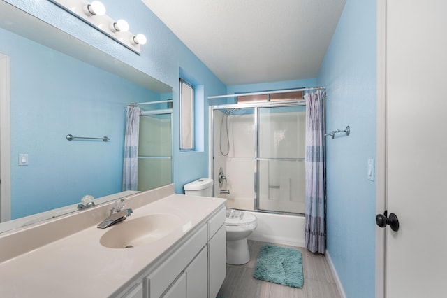 full bathroom featuring vanity, a textured ceiling, bathtub / shower combination, and toilet