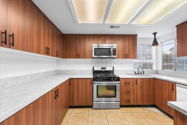 kitchen with sink, decorative light fixtures, light tile patterned floors, and appliances with stainless steel finishes