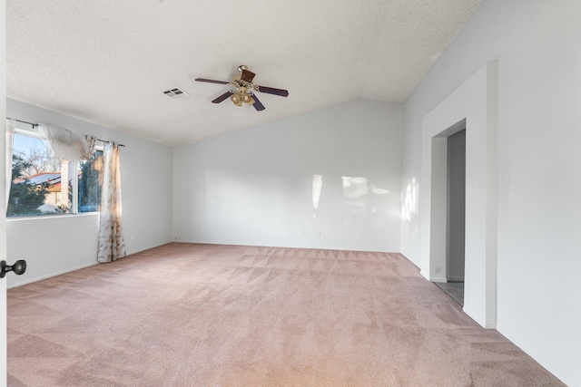 carpeted spare room with ceiling fan, lofted ceiling, and a textured ceiling