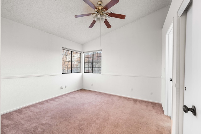 spare room featuring ceiling fan, light colored carpet, lofted ceiling, and a textured ceiling