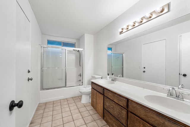 full bathroom with tile patterned flooring, vanity, toilet, and combined bath / shower with glass door