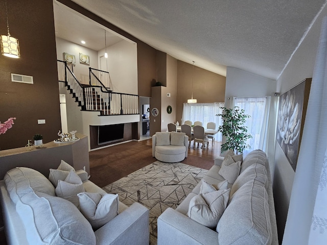 403 Sunrise Ter, Palmdale, CA 93551 - living room featuring visible vents, a textured ceiling, high vaulted ceiling, and stairway
