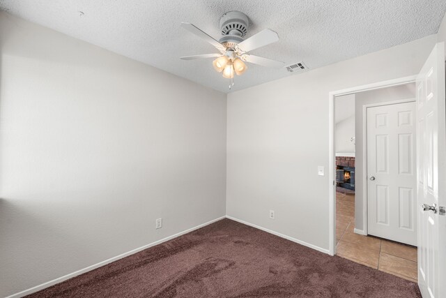 38115 E 41st St, Palmdale, CA 93552 - spare room featuring a ceiling fan, a fireplace, carpet, baseboards, and a textured ceiling