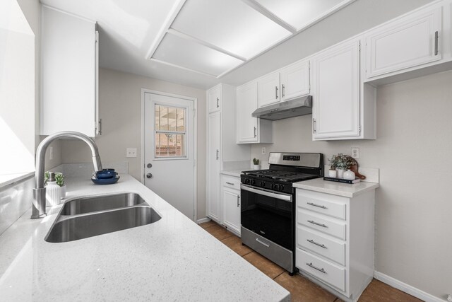 38115 E 41st St, Palmdale, CA 93552 - kitchen with gas range, under cabinet range hood, a sink, and white cabinetry