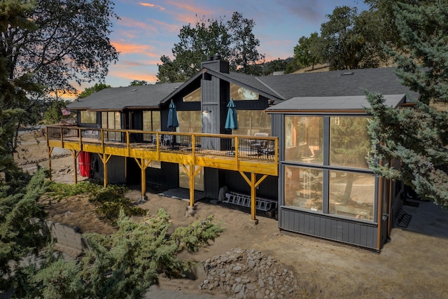 back house at dusk with a wooden deck