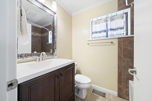 bathroom with tiled shower, vanity, toilet, and ornamental molding